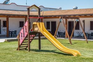 um parque infantil com um escorrega num quintal em Il mondo dei sogni em Porto Cesareo