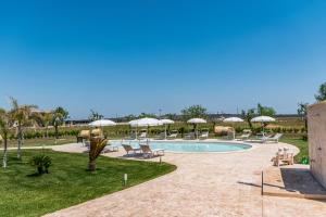 uma piscina com cadeiras e guarda-sóis num resort em Il mondo dei sogni em Porto Cesareo