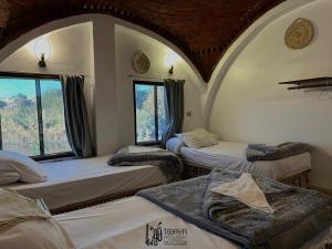 a room with three beds and a window at Torya Nubian House in Aswan