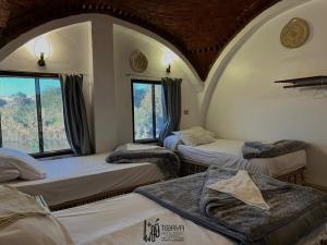 una camera con tre letti e una finestra di Torya Nubian House a Aswan