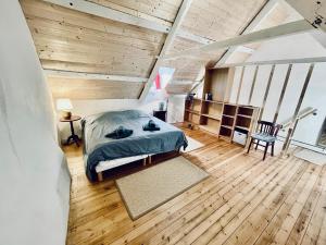 1 dormitorio con 1 cama y suelo de madera en Le penty de Lesquiffinec, en Crozon