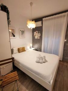 a bedroom with a large white bed with towels on it at Pequeño Alojamiento con Mini Piscina - NO climatizada in Valencia