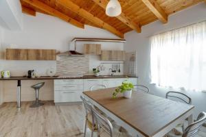 eine Küche mit einem Holztisch und einer Holzdecke in der Unterkunft La Casa delle Zie - Cabras in Càbras