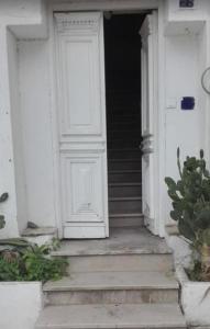 a white door on a white house with stairs at la casbah in Hammamet