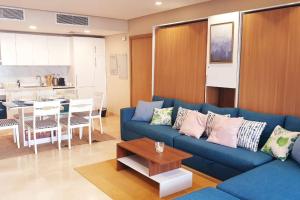 ein Wohnzimmer mit einem blauen Sofa und einem Tisch in der Unterkunft Mangroovy - 1BR GF +2 wall beds Garden & Pool view in Hurghada