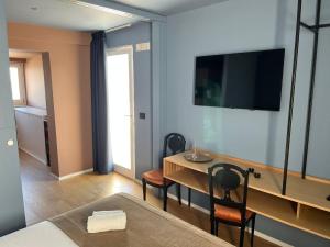 a room with a bed and a table with a television at La Finestra Sul Mare in Bari