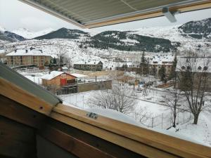 a view from a window of a town in the snow at Dúplex con moderna y amplia cocina Erta 6 in Pla de l'Ermita