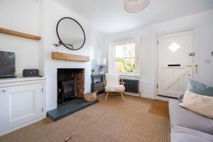 a living room with a couch and a fireplace at 3 Lower Falkland Cottage Long Melford in Sudbury