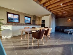 a kitchen and dining room with a table and chairs at Nachtegael Zomerhuis, idyllische woning in de Vlaamse Ardennen in Kluisbergen