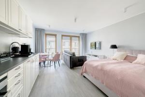 sypialnia z łóżkiem, kuchnia i stół w obiekcie DR Apartments - Mavik w mieście Sopot