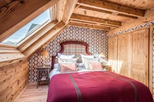 a bedroom with a red bed in a attic at Casa Bosque by Totiaran in Naut Aran