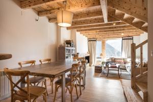 Casa Bosque by Totiaran في Naut Aran: غرفة طعام مع طاولة وكراسي خشبية