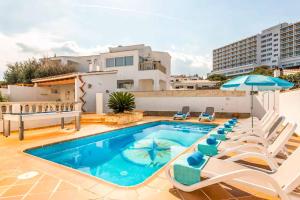 una piscina con sillas y sombrilla en Vista Arenal, en Arenal d'en Castell