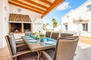 een eetkamer met een tafel en stoelen en een open haard bij Vista Arenal in Arenal d'en Castell