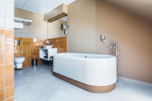 a large bathroom with a tub and a toilet at Arensburg Boutique Hotel & Spa in Kuressaare