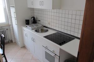 eine kleine Küche mit einer Spüle und einer Theke in der Unterkunft Apartments Mayen in Mayen
