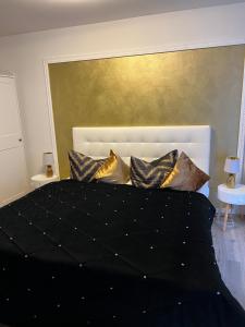 a bedroom with a black bed with gold pillows at Appartement im Funkenhöfchen in Pirna