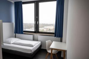 Habitación con cama, escritorio y ventana. en apartmenthaus international en Múnich