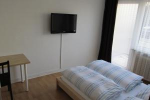 Zimmer mit einem Bett und einem TV an der Wand in der Unterkunft Apartments Mayen in Mayen