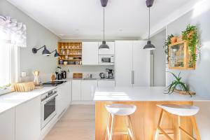 a kitchen with white cabinets and white countertops at Villa Björkbacken in Nummela