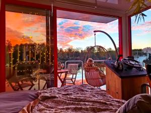 - une chambre avec un balcon offrant une vue sur le coucher du soleil dans l'établissement Escale Royale Port Ilon, à Saint-Martin-la-Garenne