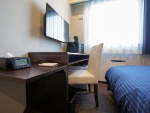 a hotel room with a desk and a bed at HOTEL LiVEMAX Osaka Umeda Nakatsu in Osaka +10 photos