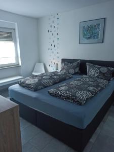 a bedroom with two beds with black pillows at Ferienhaus Laila in Hochstetten-Dhaun