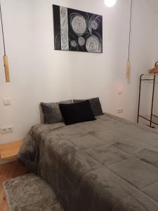 a bedroom with a large bed with a painting on the wall at Moinho das fragas in Figueiró dos Vinhos