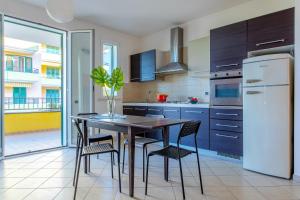 una cucina con tavolo, sedie e frigorifero di ETOILE - Narramondo Villas a Giulianova