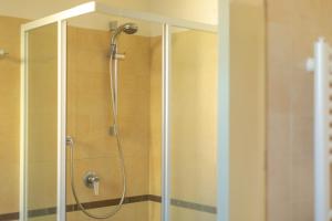 una doccia con una porta in vetro in un bagno di ETOILE - Narramondo Villas a Giulianova Altre 8 foto