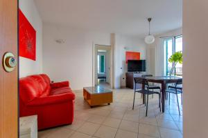 un soggiorno con un divano rosso e un tavolo di ETOILE - Narramondo Villas a Giulianova