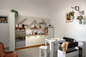 una cocina con armarios blancos, una mesa pequeña y un mantel en Centro e Spiaggia ardesia en Anguillara Sabazia