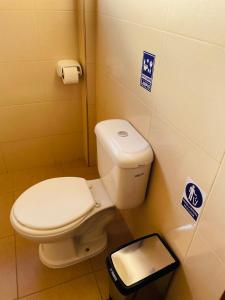 a bathroom with a toilet and a trash can at DIAMEZ HOTEL PLAZA in Sacaba