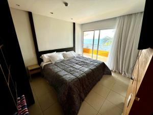 a bedroom with a bed with a view of the ocean at Ap climatizado com vista mar no Rio Vermelho in Salvador
