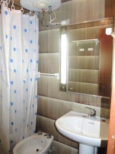 La salle de bains est pourvue d'un lavabo, de toilettes et d'un miroir. dans l'établissement Warm two-room flat with terrace near the beach, à Bibione