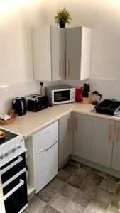 a kitchen with white cabinets and a microwave at Studio3 Ave house in Scarborough