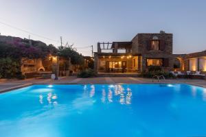 una gran piscina azul frente a una casa en Villa Myrto, breathtaking Aegean view, 5' from Koundouros beach, en Koundouros