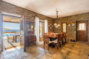 comedor con mesa de madera y sillas en Villa Myrto, breathtaking Aegean view, 5' from Koundouros beach, en Koundouros
