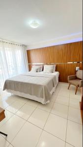 a bedroom with a large bed and a chair at Avelan Plaza Hotel in Nossa Senhora da Glória