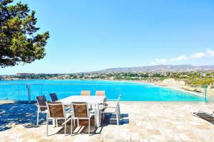 佩亚Coral Bay Beach Villa的桌椅,享有游泳池的景色