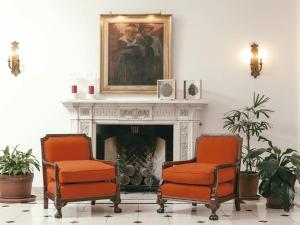 a living room with two chairs and a fireplace at Solar De La Plaza in Salta