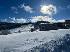 a snow covered field with buildings in the background at Panorama apartmán 44-C in Donovaly