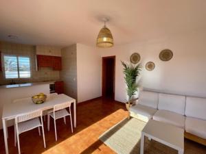 a living room with a white couch and a table at Apto. S'aigua dolça 1 in Son Carrio