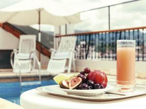 a plate of fruit and a glass of juice on a table at Solar De La Plaza in Salta