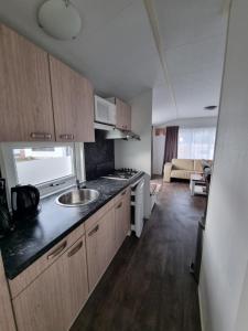 デ・コーフにあるChalet MaMaMia nr. 54 op Chaletpark Bregkoogのシンクとカウンタートップのあるキッチン