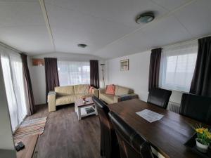 デ・コーフにあるChalet MaMaMia nr. 54 op Chaletpark Bregkoogのテーブルとソファのあるリビングルーム