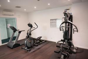 um ginásio com três bicicletas de exercício numa sala em apartmenthaus international em Munique