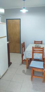 eine Küche mit einem Tisch, einem Tisch und einem Kühlschrank in der Unterkunft COMPLEJO Aires del Ñapindá in Paraná