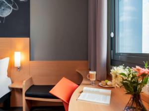 a room with a desk with a laptop and a plate of food at ibis Ankara Airport Hotel in Ankara
