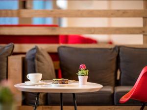 a table with a cup of coffee and a flower on it at ibis Ankara Airport Hotel in Ankara
